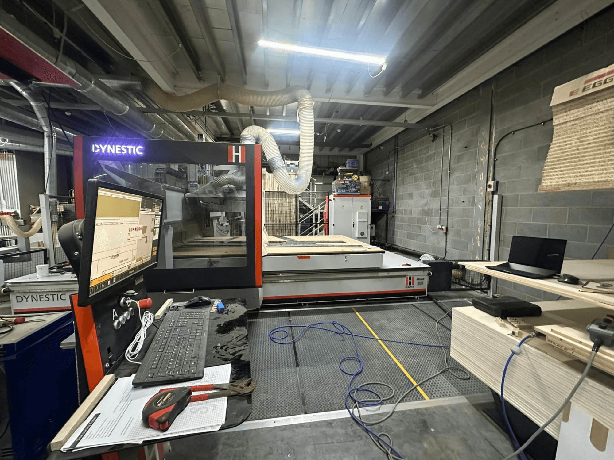 HOLZHER Dynestic 7535 houtmolen in werkplaats, met bedieningspaneel, monitor en materialen op werktafel, vooraanzicht.