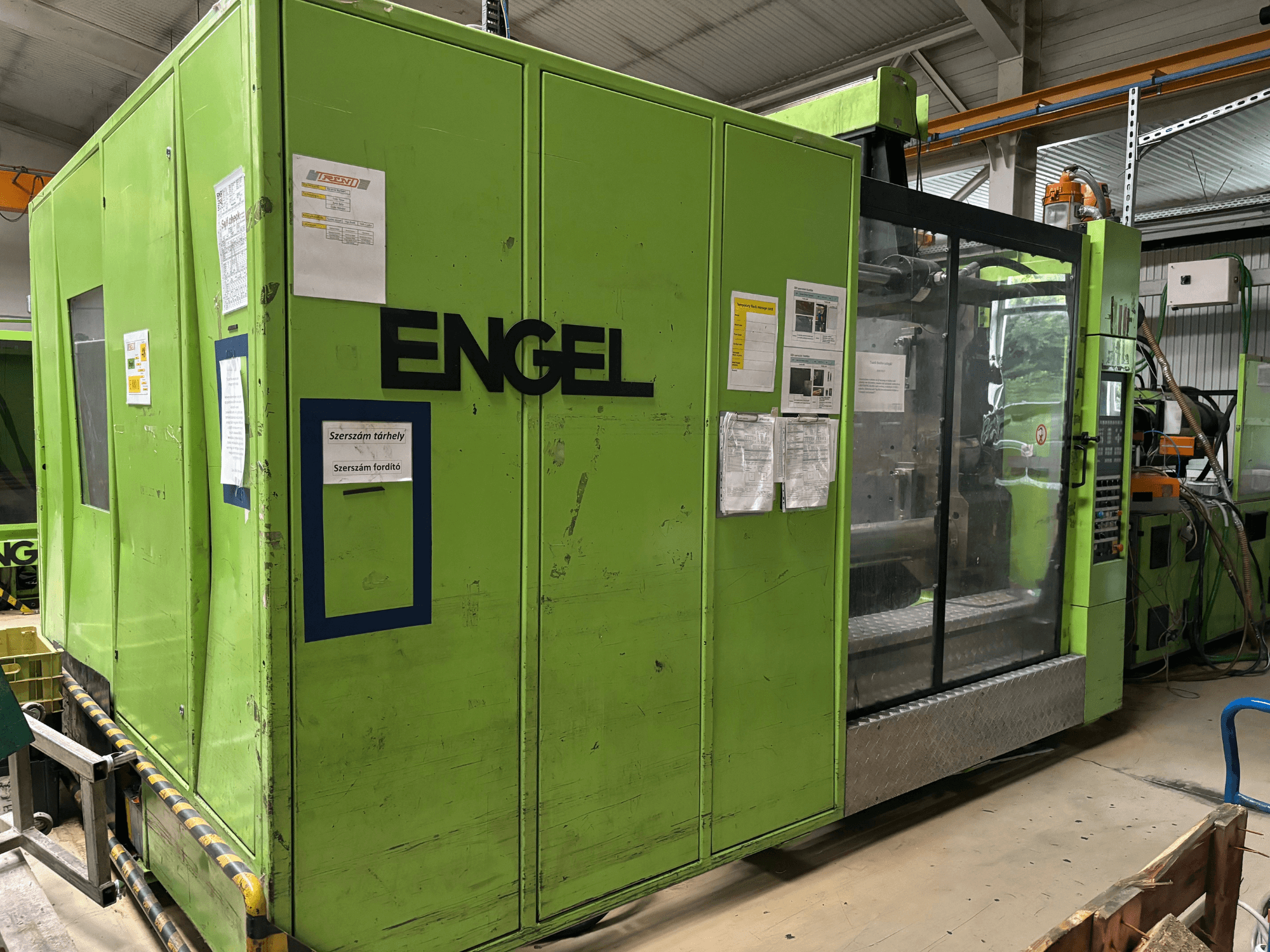 Hydraulische spuitgietmachine Engel DUO 5550/800, vooraanzicht, met groene buitenkant en transparant toegangspaneel.