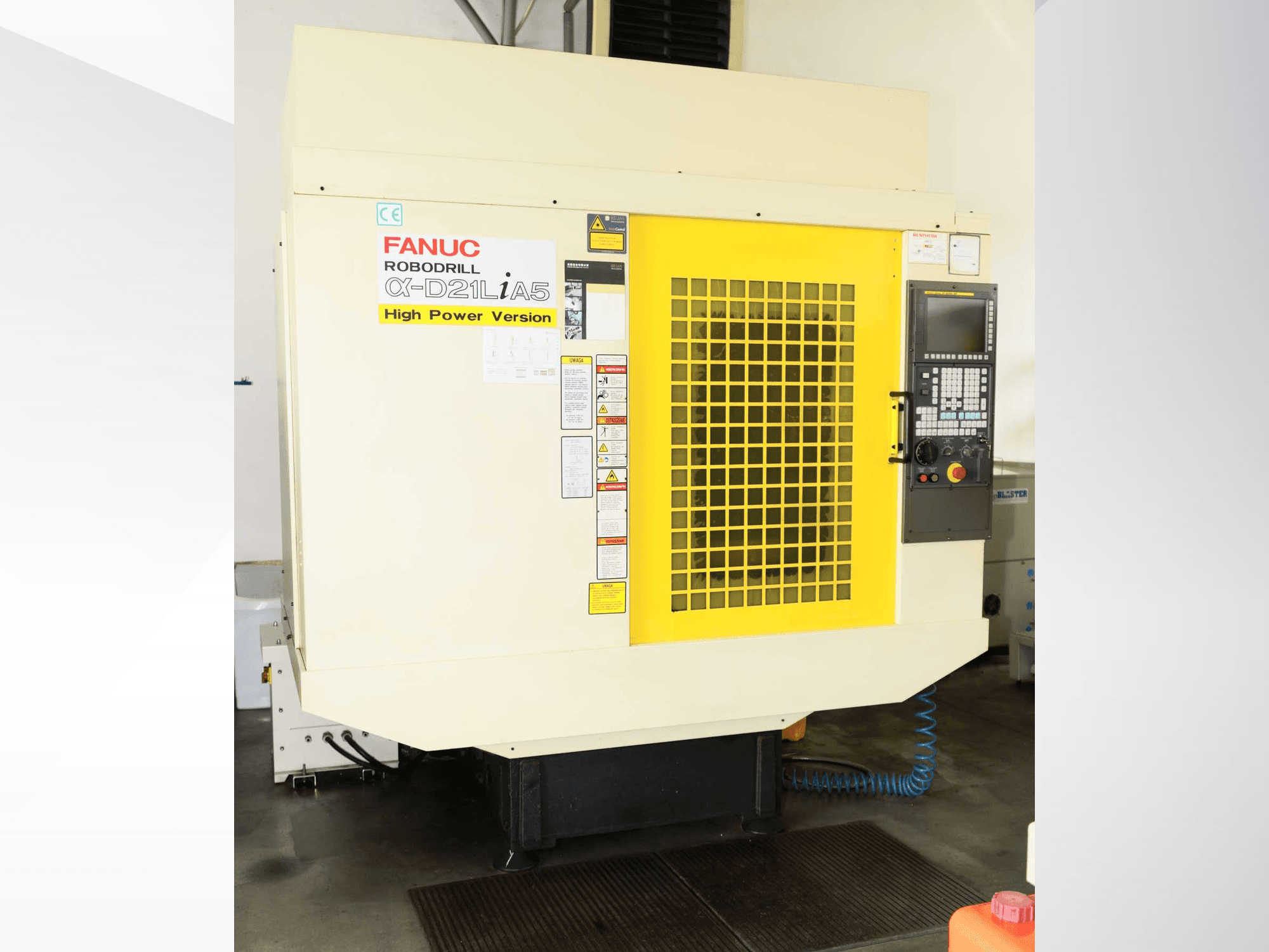 FANUC ROBODRILL α-D21LiA5 verticaal bewerkingscentrum, vooraanzicht met geel veiligheidsrooster en details van het bedieningspaneel.