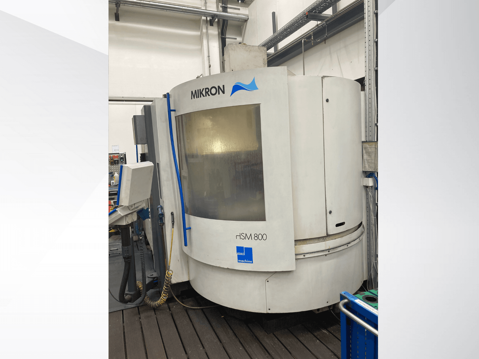 Mikron rISM 800 CNC machine, vooraanzicht met bedieningspaneel, cilindrisch ontwerp en blauwe accenten, opgesteld in een werkplaatsomgeving.