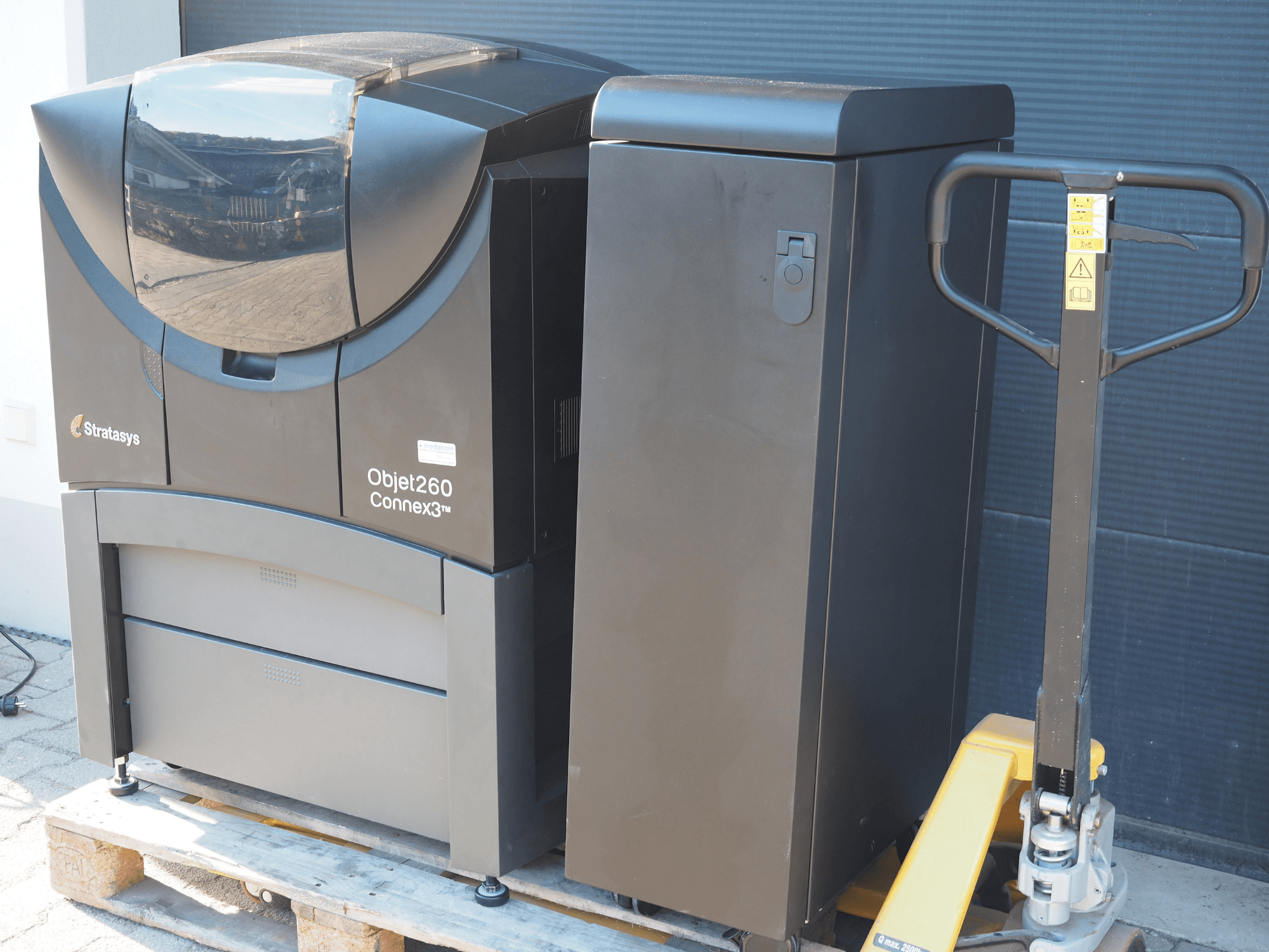 Stratasys Objet260 Connex3 kunststof 3D printer, zijaanzicht, heeft een compact ontwerp met bedieningspaneel en aangesloten materiaalbak.