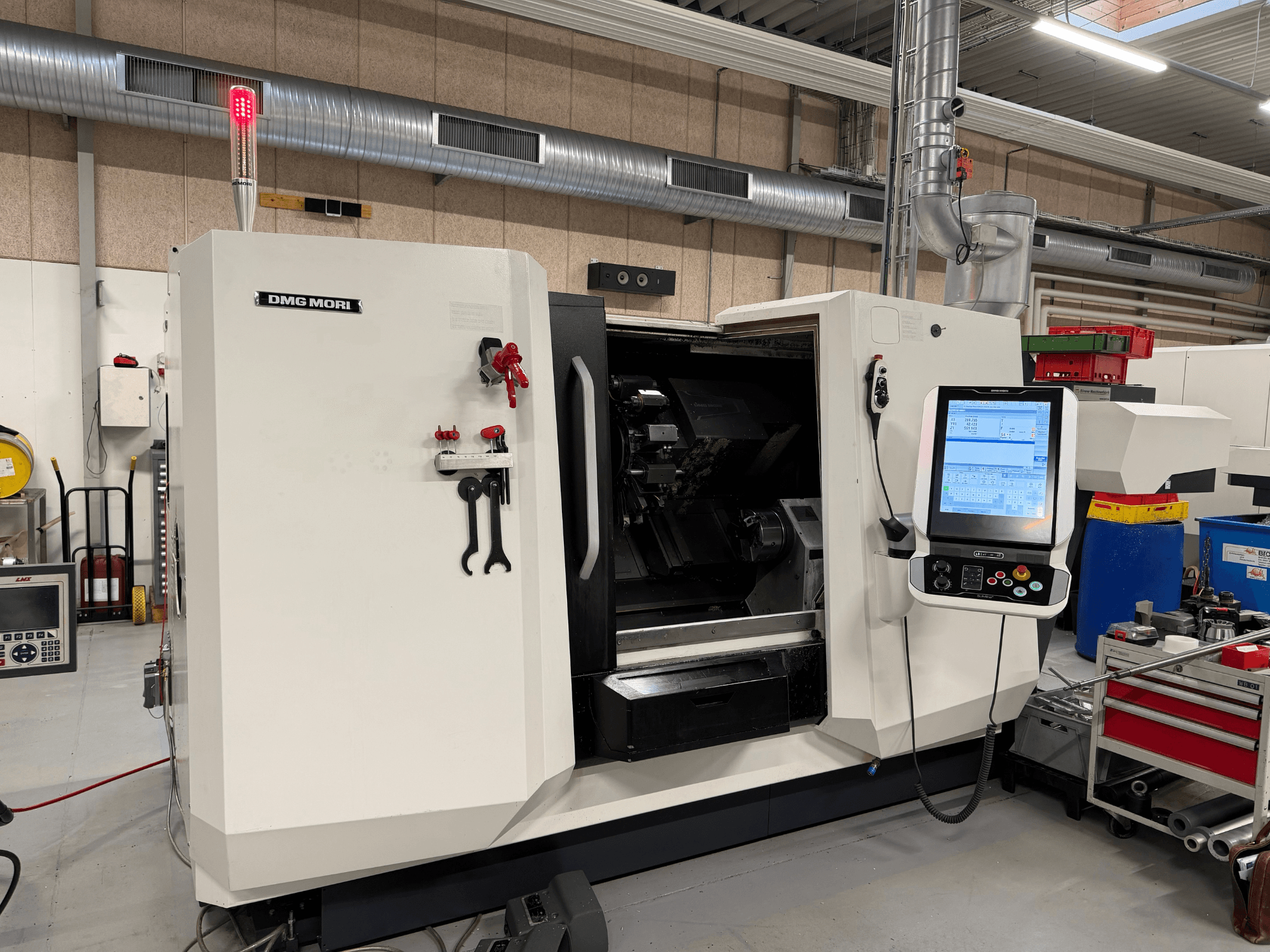 DMG MORI CLX 450 V6 horizontale draaibank, vooraanzicht met zichtbaar bedieningspaneel, noodstop en veiligheidslampje.