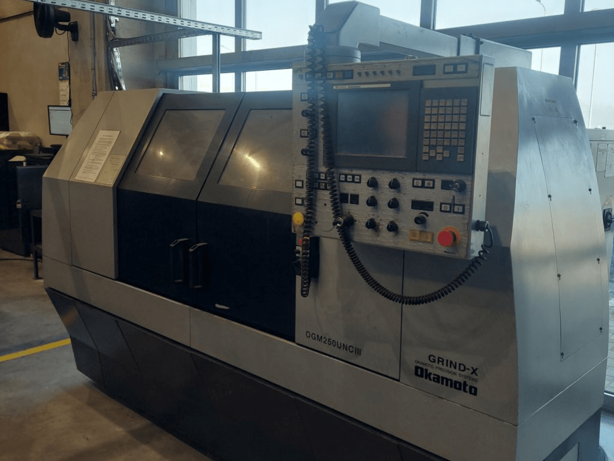 OKAMOTO OGM 250 UNC III cilindrische slijpmachine, vooraanzicht, met het bedieningspaneel en het ontwerp met twee vensters.
