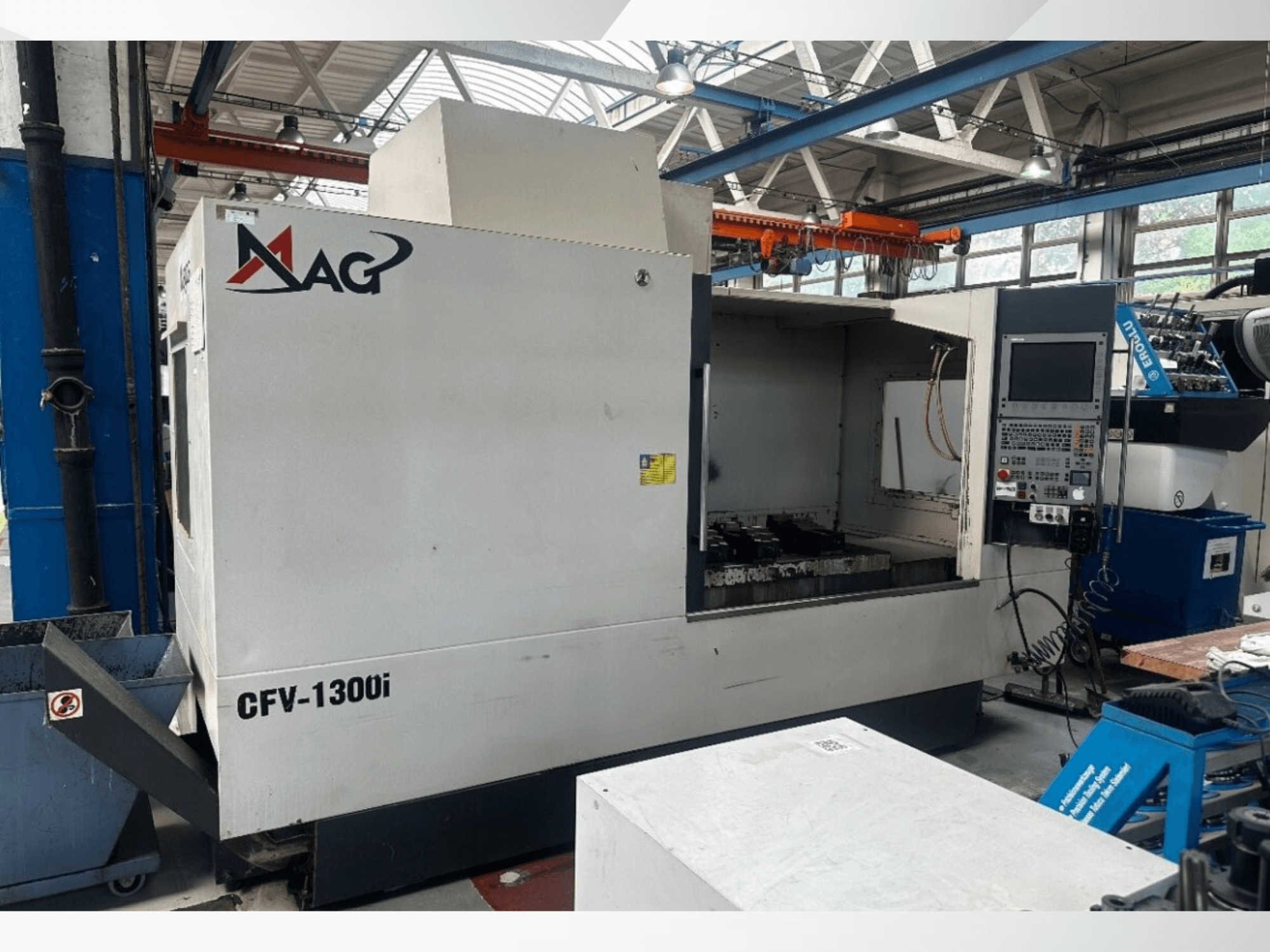 Verticaal bewerkingscentrum Cincinnati MAG CFV1300i in een werkplaats, vooraanzicht met het bedieningspaneel en het interieur van de machine.