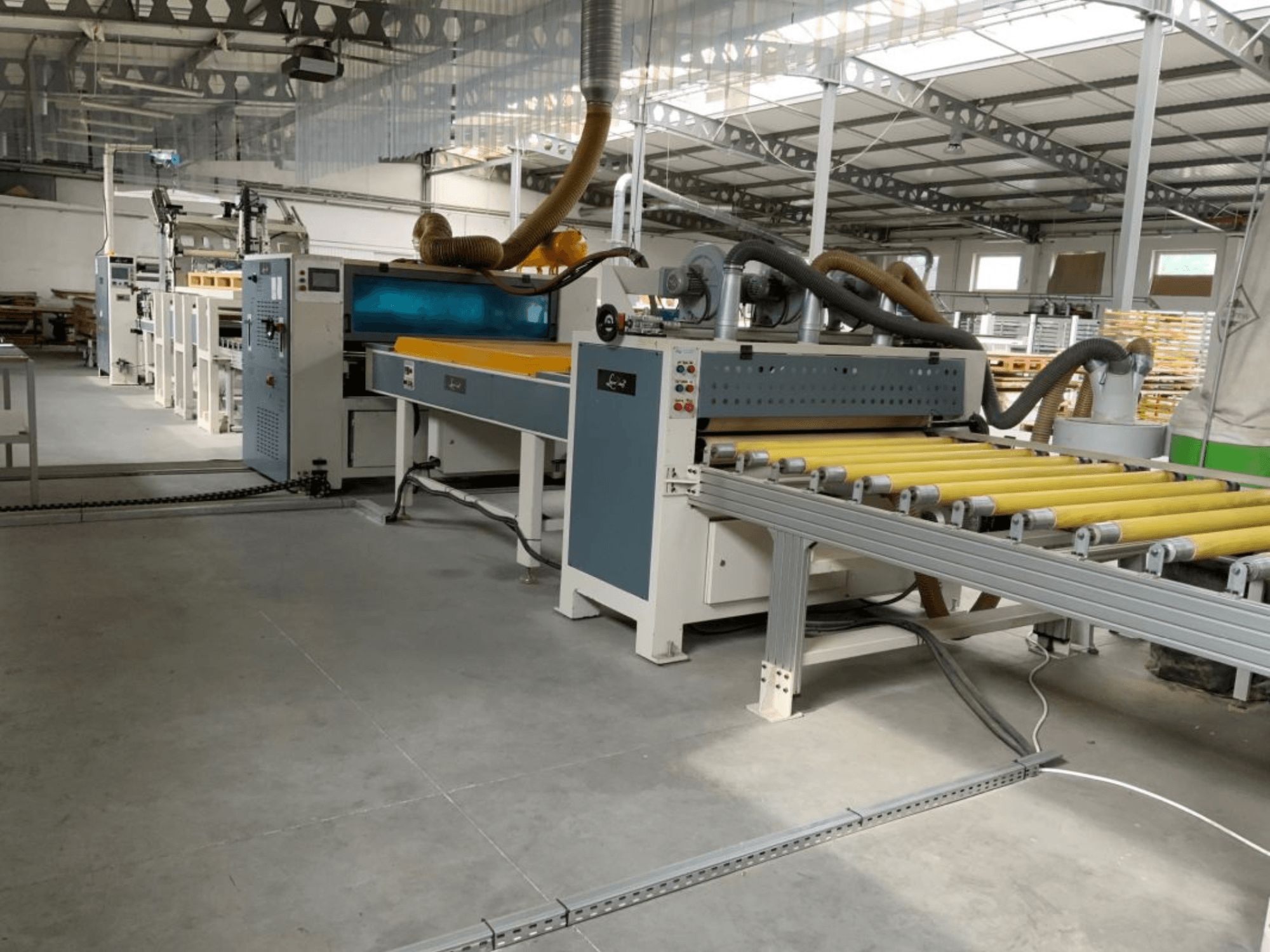 MASTER PUR-1400-lamineerpers in een fabrieksomgeving, vooraanzicht, met weergave van de rollen en de bedieningselementen.