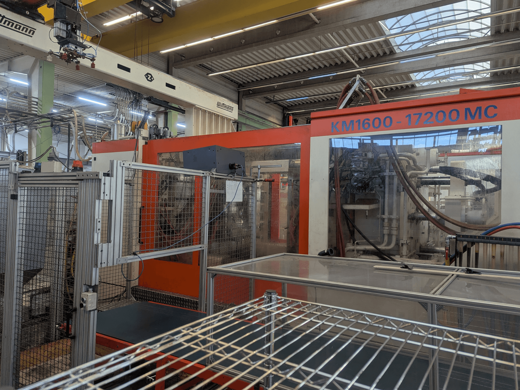 Hydraulische spuitgietmachine Krauss Maffei KM 1600-17200MC, vooraanzicht met zichtbaar bedieningspaneel en hydraulische leidingen.