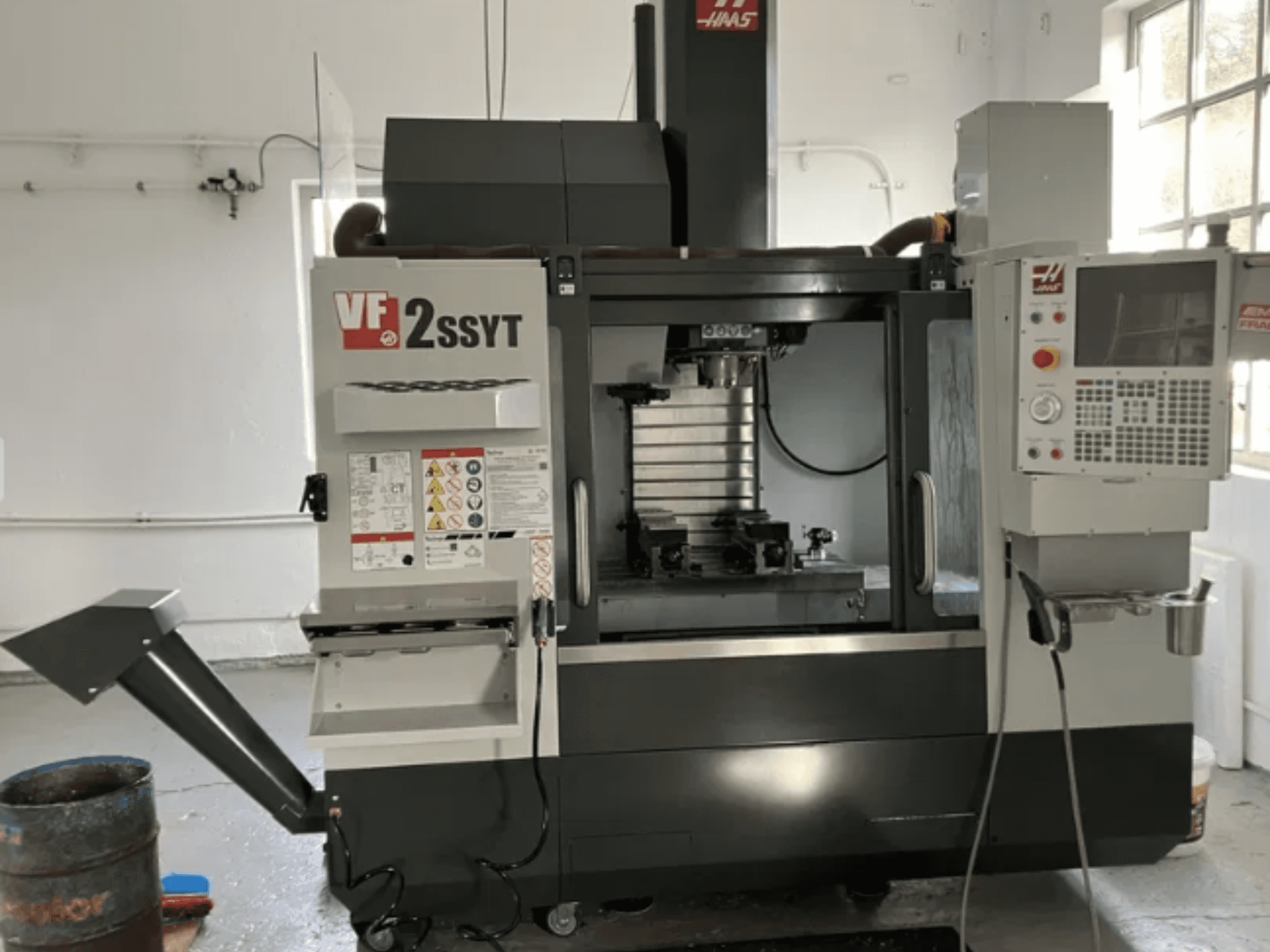 Haas VF-2SSYT CNC-frees, vooraanzicht, met bedieningspaneel, gereedschaphouder en koelvloeistofsysteem voor metaalbewerking.