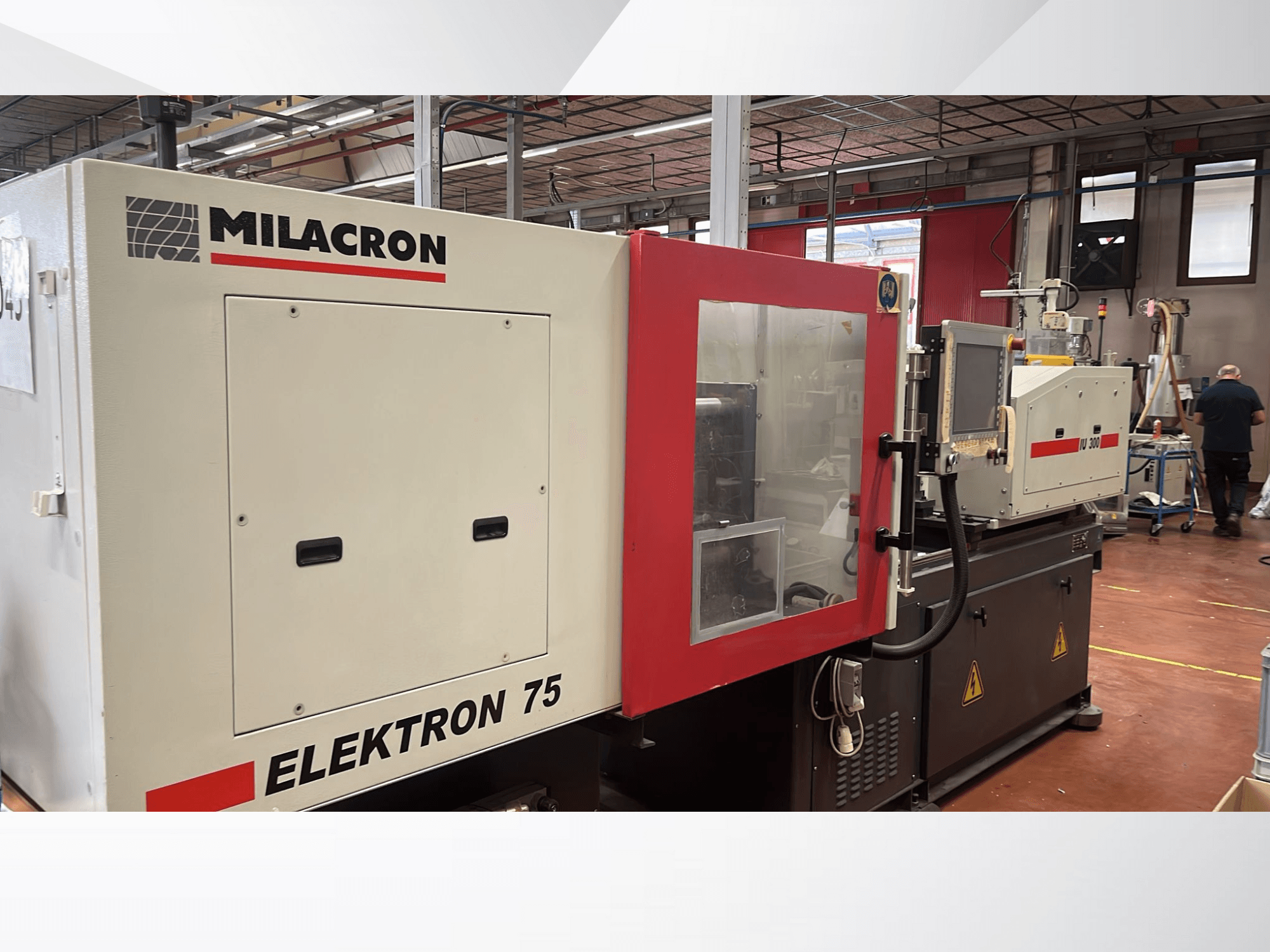 Milacron Elektron 75 spuitgietmachine in een werkplaats, zijaanzicht met het bedieningspaneel en de mechanische onderdelen.