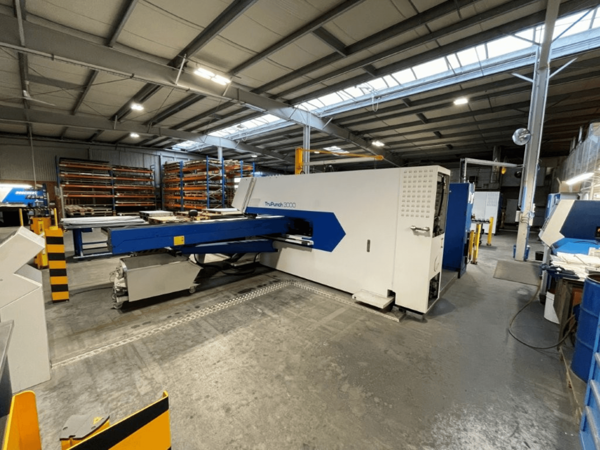De CNC-ponsmachine TRUMPF TruPunch 3000 in een fabrieksomgeving; het vooraanzicht toont het blauw-witte ontwerp en de functionele onderdelen.