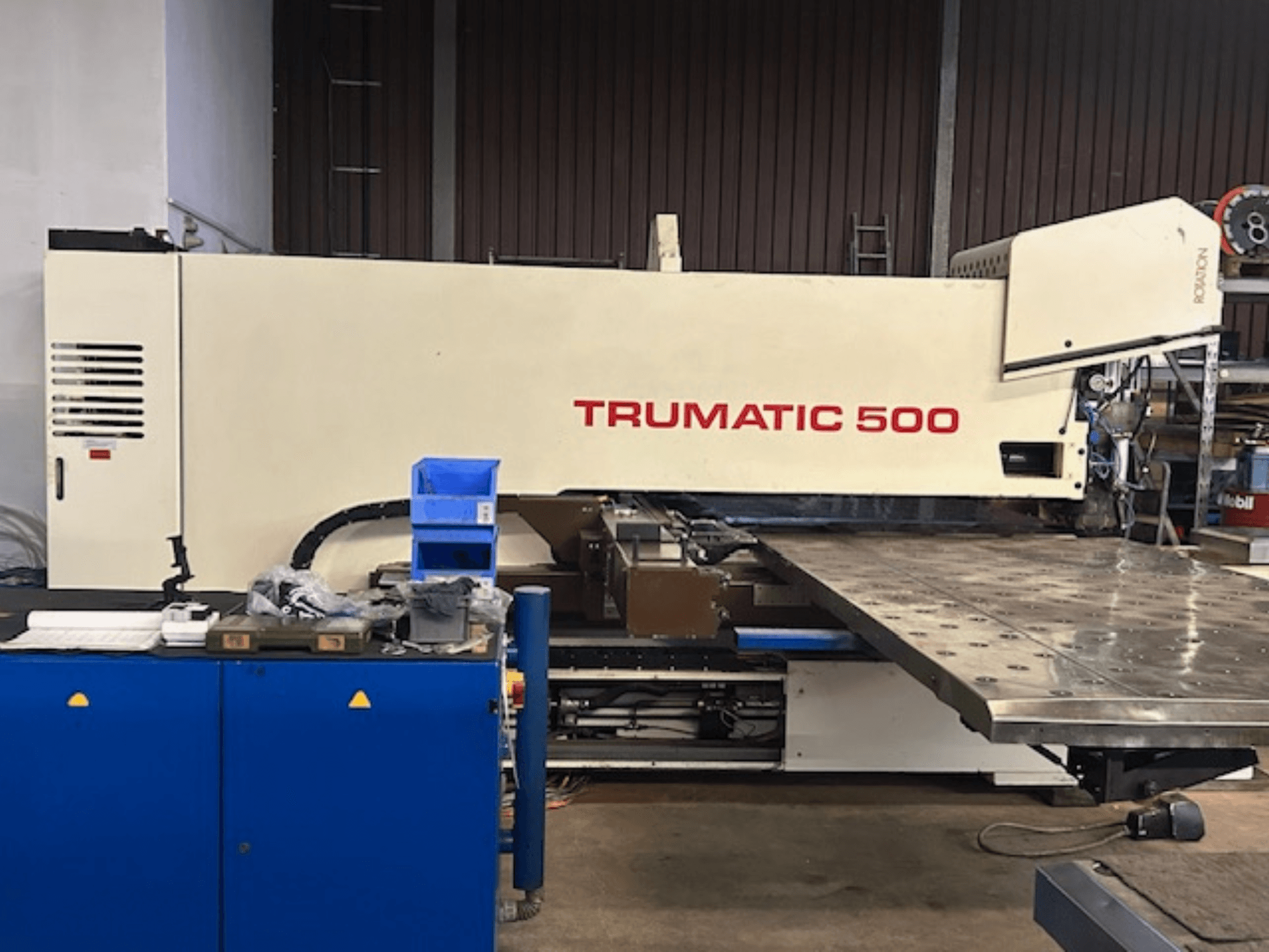 TRUMPF TRUMATIC 500 CNC ponsmachine, vooraanzicht, met bedieningspaneel en een grote werktafel met geperforeerd oppervlak.