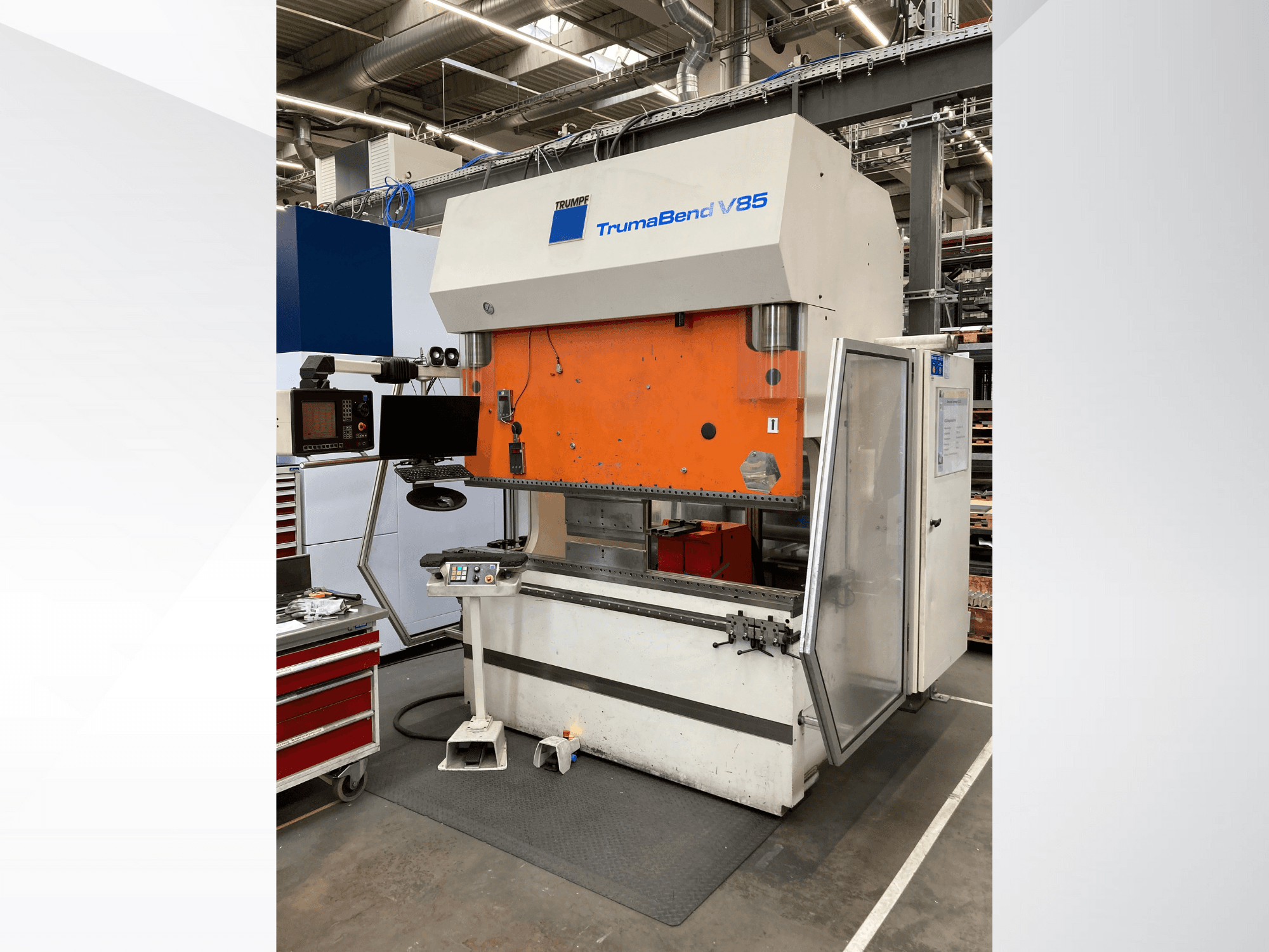 TruMatic V85-buigmachine in een fabriek, met oranje voorpaneel, bedieningsscherm en open zijdeur, zijaanzicht.