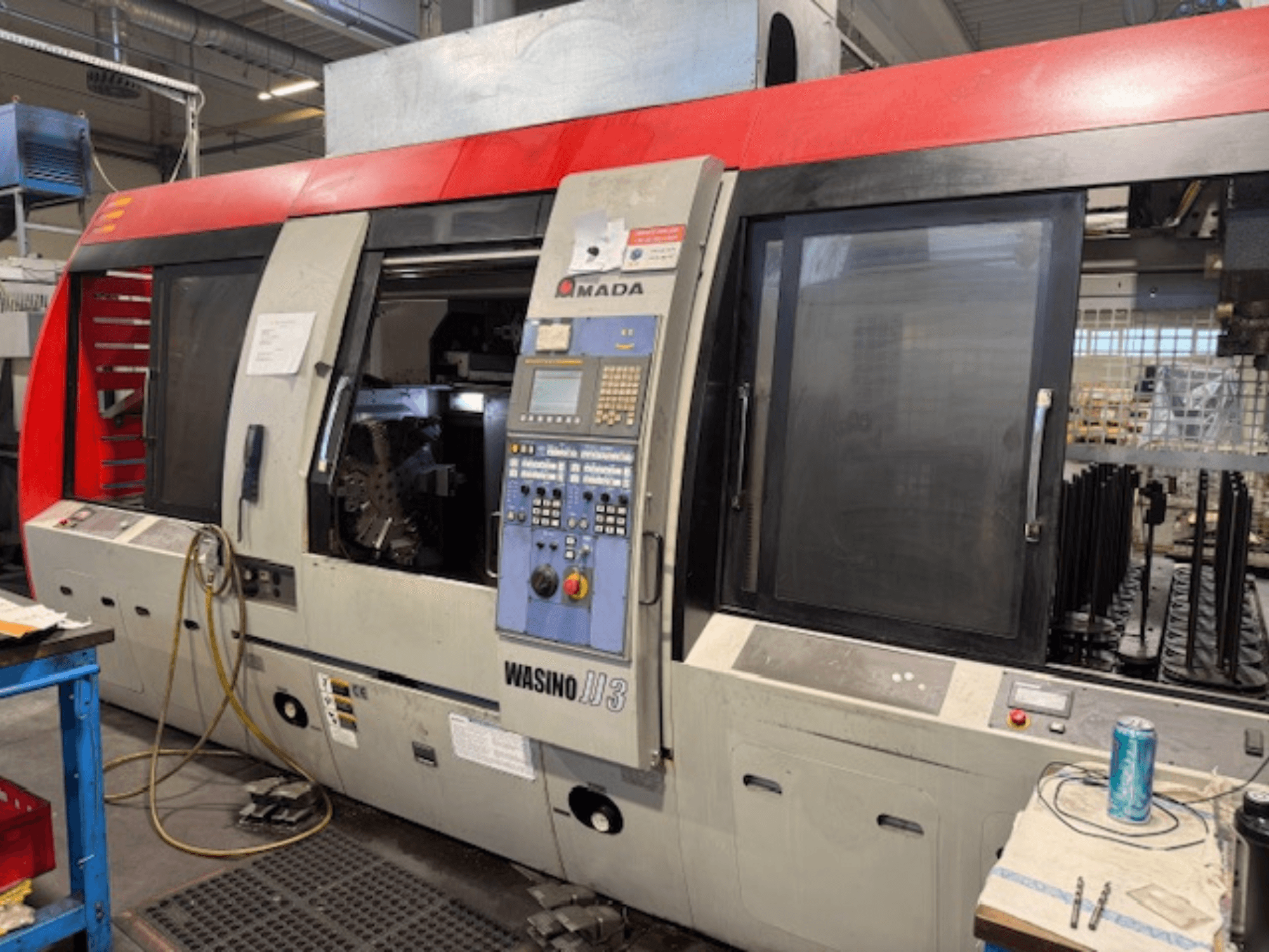 AMADA Wasino JJ3 horizontale draaimachine, vooraanzicht met bedieningspaneel en open kamer voor bewerking.