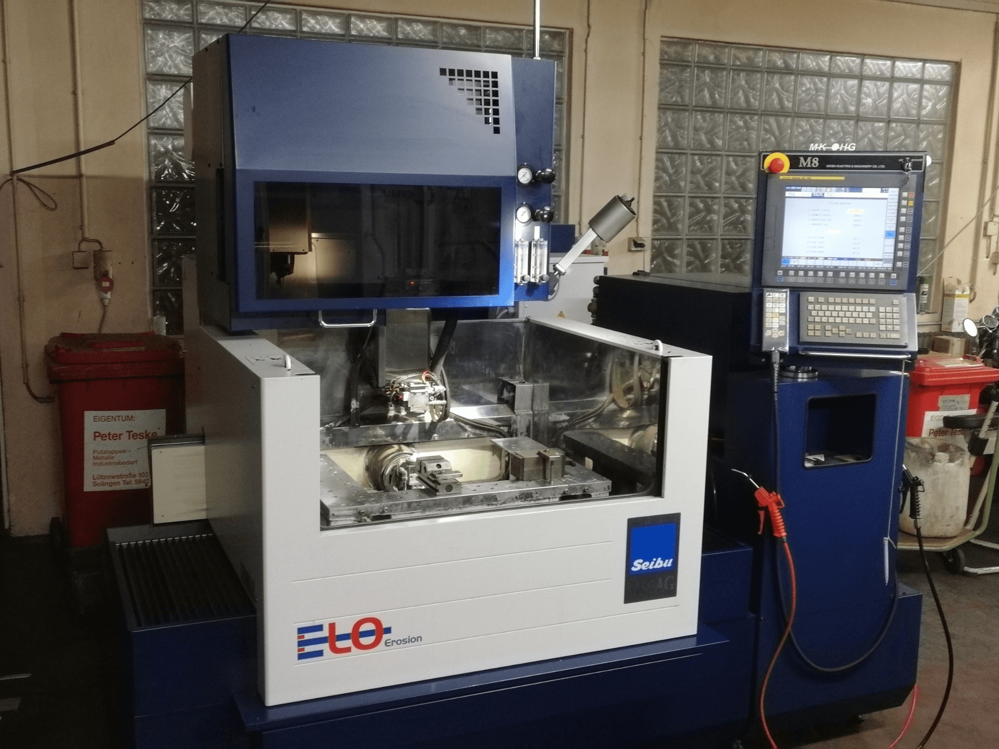 ELO Seibu erosiemachine gezien vanaf de voorkant, met een bedieningspaneel en zichtbaar werkgebied met metalen onderdelen.