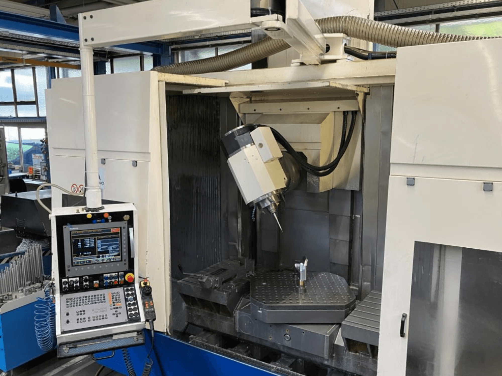 Huron EX-C universeel bewerkingscentrum, vooraanzicht, met bedieningspaneel, spindelkop en werkstukopstelling op de tafel.
